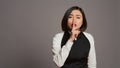 Restaurant hostess showing silence symbol in studio