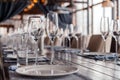 Restaurant interior, serving, wine and water glasses, plates, forks and knives on textile napkins stand in a row on vintage gray Royalty Free Stock Photo