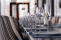 Restaurant interior, serving, wine and water glasses, plates, forks and knives on textile napkins stand in a row on vintage gray Royalty Free Stock Photo