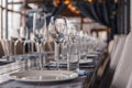 Restaurant interior, serving, wine and water glasses, plates, forks and knives on textile napkins stand in a row on vintage gray Royalty Free Stock Photo