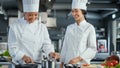 Restaurant Kitchen: Asian and Black Female Chefs Preparing Dish, Tasting Food and Doing High-Five in