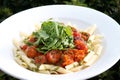 Penne pasta, roasted cherry tomatoes, rocket and pesto. Royalty Free Stock Photo