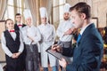 Restaurant manager and his staff in kitchen. interacting to head chef in commercial kitchen. Royalty Free Stock Photo