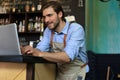 Restaurant manager working on laptop, counting profit Royalty Free Stock Photo