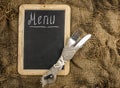 Restaurant menu. Top view of chalkboard menu laying on very old burlap background with copy space Royalty Free Stock Photo