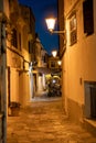 Restaurant in Old illuminated narrow street in Mahon at night - Menorca, Spain