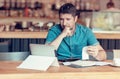 Restaurant owner checking monthly reports on a tablet, bills and expenses of his small business. Start-up entrepreneur concerned Royalty Free Stock Photo