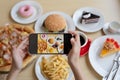 restaurant owner takes a picture of the food on the table with a smartphone to post on a website. Online food delivery, ordering