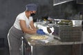 Restaurant professional open kitchen, Woman in a mask on her face, preparing pizza, new measures to fight the virus