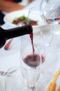 The process of pouring red wine from a bottle into a glass in a restaurant Royalty Free Stock Photo