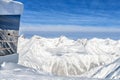 Restaurant or residential building on top of austrian alpine mountain peaks covered with snow layer in winter at bright cold Royalty Free Stock Photo