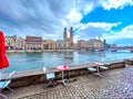 Restaurant\'s outdoor seating on the Wuhre riverside street with view on Grossmunster church, Zurich, Switzerland