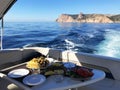 Restaurant at sea shore against blue water and Yacht Port of Aegean coast on Cesme. Marble Table with plate of beef Royalty Free Stock Photo