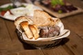 Restaurant serving of assortment of bread on napkin in basket with other dishes of background Royalty Free Stock Photo