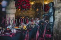The Restaurant Set Table With Burgundy Chairs And A Tablecloth. On The Table Forged Stands For Flowers And Candles. Dark