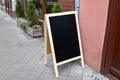 Restaurant sidewalk chalkboard sign board. Old Blak Signboard on the street. Blank store signage sign design mockup