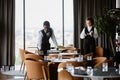 Restaurant staff preparing for grand opening with two servers setting tables Royalty Free Stock Photo