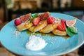 Restaurant sweet breakfast. Small pancakes with caramel cream and strawberries, figs, raspberries, fruit and meant on top. Royalty Free Stock Photo