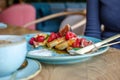 Restaurant sweet breakfast. Small pancakes with caramel cream and strawberries, figs, raspberries fruit and mint on top. Royalty Free Stock Photo