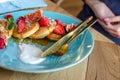 Restaurant sweet breakfast. Small pancakes with caramel cream and strawberries, figs, raspberries fruit and mint on top. Royalty Free Stock Photo