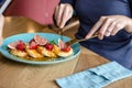 sweet breakfast. Small pancakes with caramel cream and strawberries, figs, raspberries fruit and mint on top. Process of eating Royalty Free Stock Photo