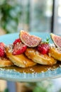Restaurant sweet breakfast. Waiter hold small pancakes with caramel cream and strawberries, figs, raspberries, fruit  on top. Royalty Free Stock Photo