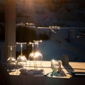 Restaurant table decorated with glasses on terrace in sunset light on the island Santorini Royalty Free Stock Photo