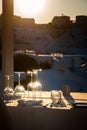 Restaurant table decorated with glasses on terrace in sunset light on the island Santorini Royalty Free Stock Photo