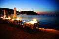 Tables on a beach promenade in Skopelos Town at sunset Royalty Free Stock Photo