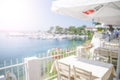 Restaurant tables and chairs below sunshades on the terrace on the seashore. Blurred scene of the restaurant in Neos marmaras, Royalty Free Stock Photo