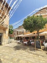 Restaurant tables on square in seaside Alcudia old town, Mallorca island, Spain Royalty Free Stock Photo