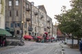 Restaurants, shops, and bars along River Street with colorful signs and balconies at sunset with a cobblestone road, people Royalty Free Stock Photo