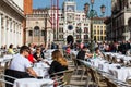 Restaurants and tourists at the famous Saint Mark Square of Venice in a beautiful sunny early spring Royalty Free Stock Photo