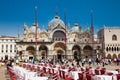Restaurants and tourists at the famous Saint Mark Square of Venice in a beautiful sunny early spring Royalty Free Stock Photo