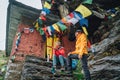 Resting Backpackers Couple tea break at small sacred Buddhist monastery decorated multicolored Tibetan prayer flags with mantras.