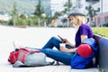 Resting blond female backpacker with mobile phone