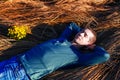 Resting calm man lies on dry grass, dreams, closed his eyes, put his hands under his head. Dressed in casual clothes Royalty Free Stock Photo