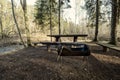 resting camping place in the woods with benches and trail in late autumn