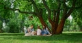 Resting family with dog on picnic. Happy people relaxing on green grass outdoors Royalty Free Stock Photo
