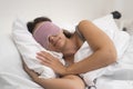 Resting female with sleep mask sleeps on light pillow covered with blanket in modern premise Royalty Free Stock Photo
