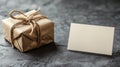 Resting in front of a rustic-looking gift box secured with natural twine is a card that is white and blank Royalty Free Stock Photo