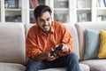 Happy young middle eastern man playing video games at home Royalty Free Stock Photo