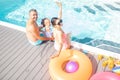 Parents and daughter feeling cheerful resting near pool