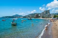 Resting people on public finely pebbly and sandy beach at a sunny summer day. Rafailovici, Montenegro Royalty Free Stock Photo