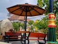 resting place benches and umbrellas made of black brown wood and iron, bright blue sky in the garden of the city of Madiun