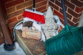 Resting from shoveling snow. - Sleeping Garden gnome statue in corner of porch with broom and snow shovel and pile of snow copy