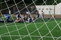 Resting soccer team. look trough goal net.