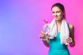 Resting time. Sporty girl with bottle of water and towel on her shoulders. Photo of fitness model isolated on white background. Royalty Free Stock Photo