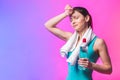 Resting time. Sporty girl with bottle of water and towel on her shoulders. Photo of fitness model isolated on white background. Royalty Free Stock Photo