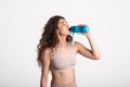 Resting time. Sporty girl with towel on shoulders drink water. Photo of muscular fitness model  on white Royalty Free Stock Photo